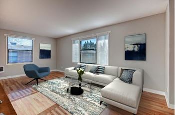 A living room with a grey couch, a blue chair, and a rug.